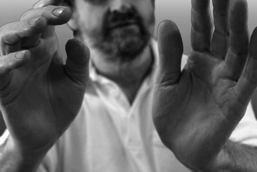 Die Hände von Olaf Garbow sind im Fokus des Bildes. Er hält diese nach vorne, so dass die Handinnenflächen zu sehen sind. Sein Gesicht und sein Oberkörper sieht man nur unscharf.