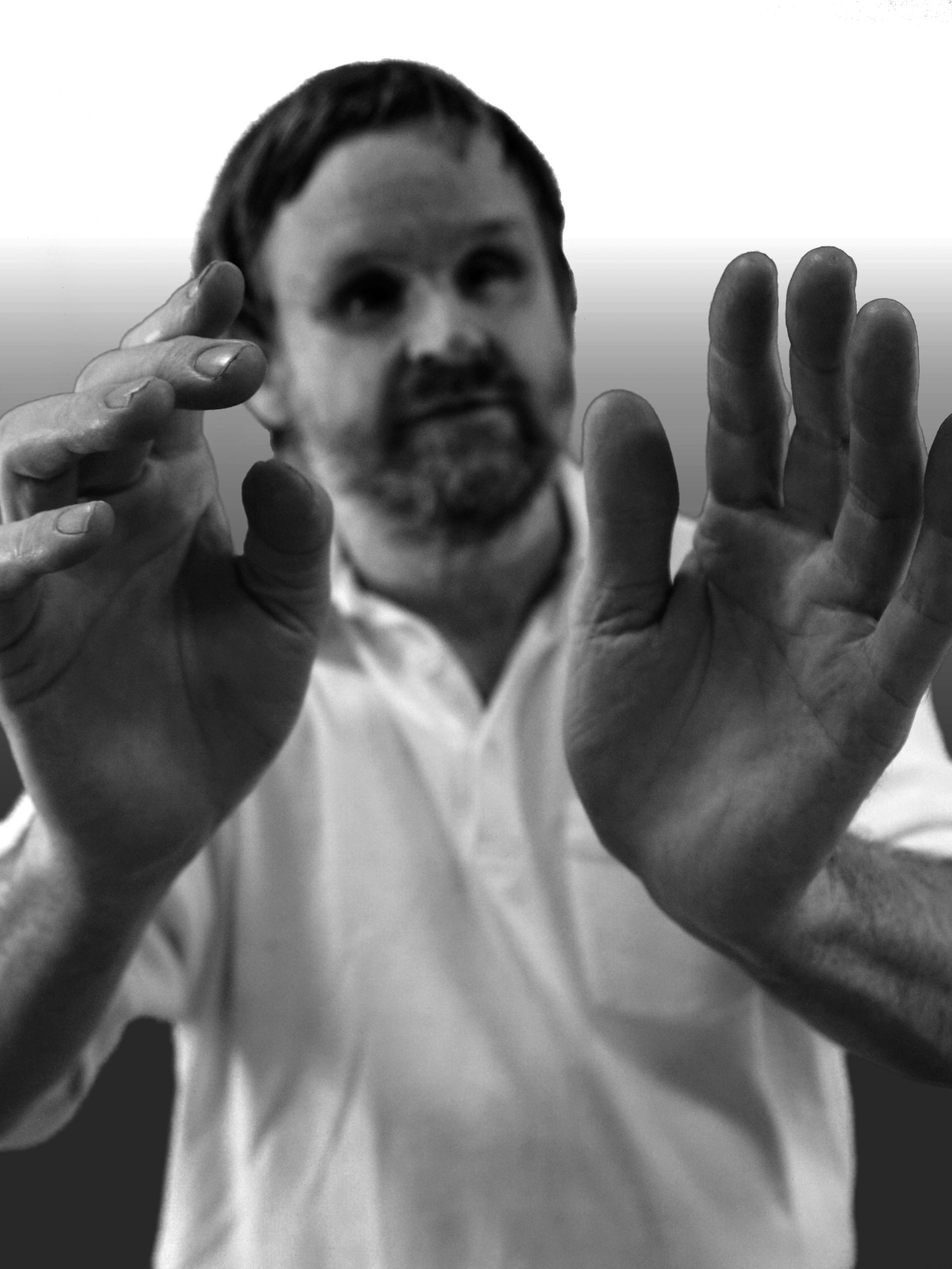 Die Hände von Olaf Garbow sind im Fokus des Bildes. Er hält diese nach vorne, so dass die Handinnenflächen zu sehen sind. Sein Gesicht und sein Oberkörper sieht man nur unscharf.