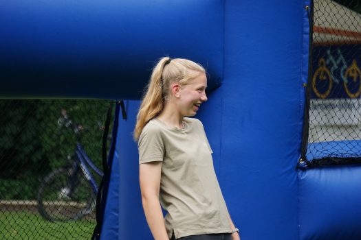 Eine junge Frau steht im aufblasbaren Fußballcourt und lacht.